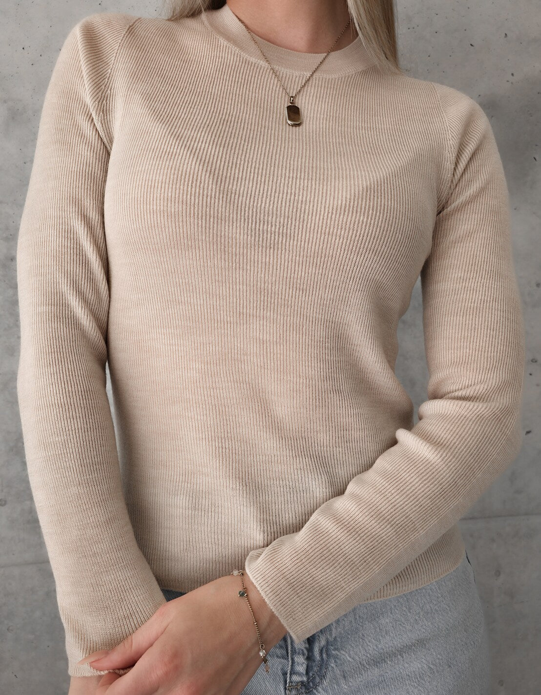 Frontale Oberkörperansicht des beigen Merino-Longsleeves mit Rundhalsausschnitt.